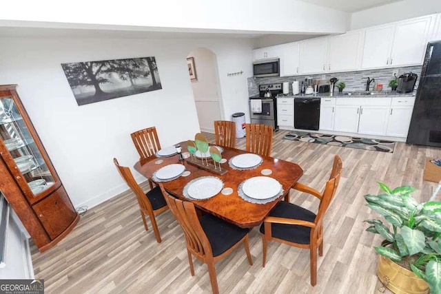 dining space featuring light hardwood / wood-style flooring and sink