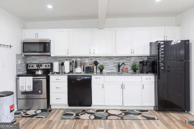 kitchen with light hardwood / wood-style floors, white cabinetry, and black appliances