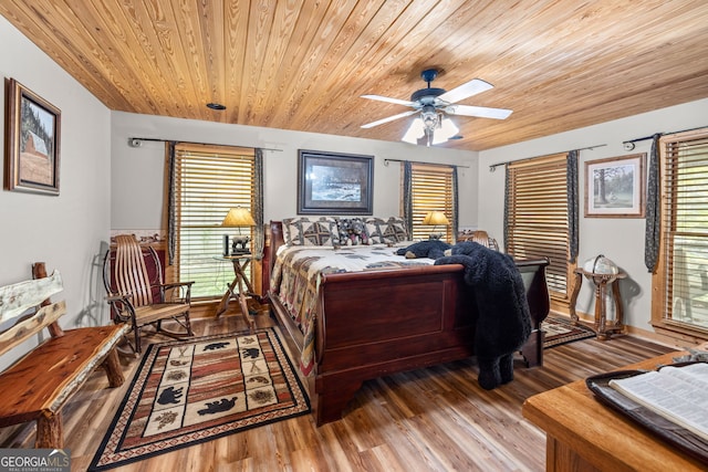 bedroom featuring multiple windows, ceiling fan, dark wood-type flooring, and wood ceiling