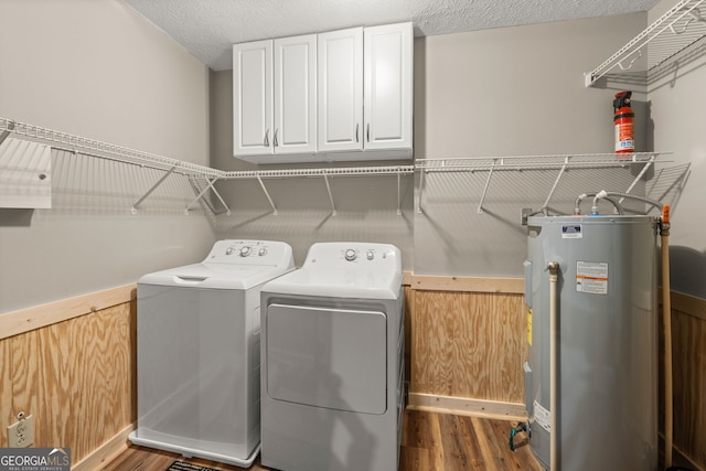 washroom with electric water heater, separate washer and dryer, a textured ceiling, and dark hardwood / wood-style flooring