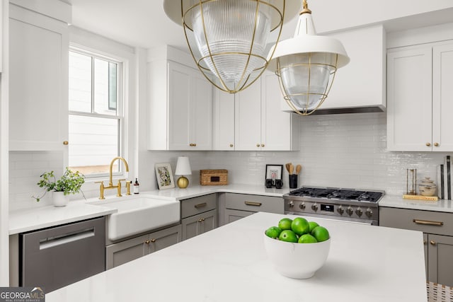 kitchen with hardwood / wood-style flooring, dishwasher, sink, a tray ceiling, and a kitchen island