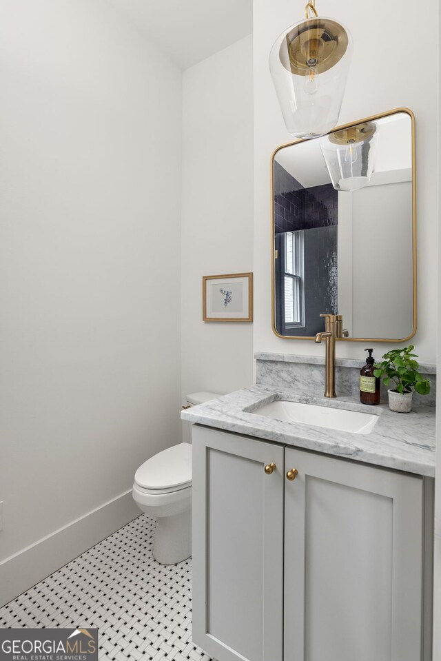 bathroom with tile patterned flooring, vanity, and toilet