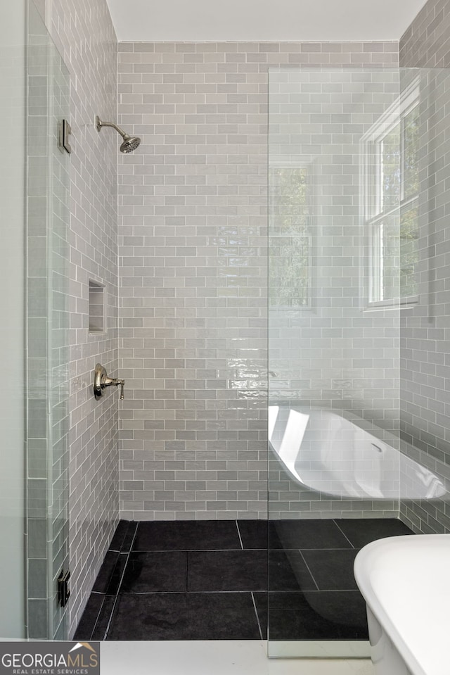 bathroom featuring tile walls, tile patterned flooring, and an enclosed shower