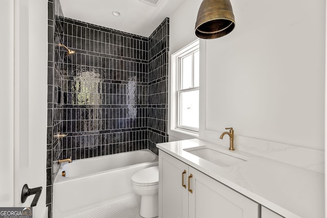 full bathroom with tiled shower / bath combo, vanity, toilet, and tile patterned floors