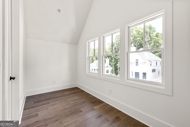 additional living space featuring lofted ceiling and dark wood-type flooring