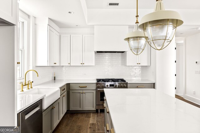 kitchen featuring stainless steel appliances, sink, dark hardwood / wood-style floors, pendant lighting, and tasteful backsplash