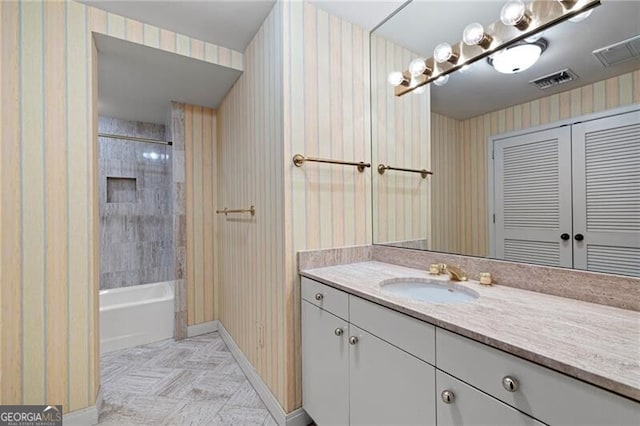 bathroom with vanity and tiled shower / bath