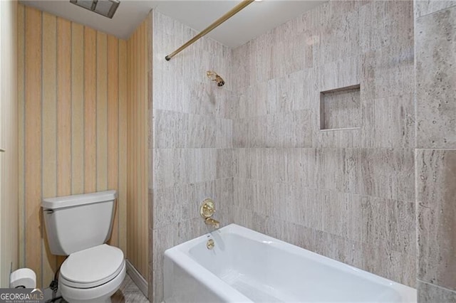 bathroom with tiled shower / bath combo and toilet