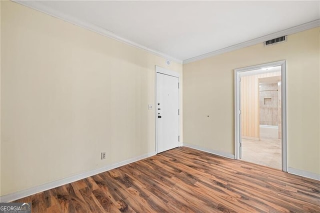 spare room featuring hardwood / wood-style flooring and crown molding