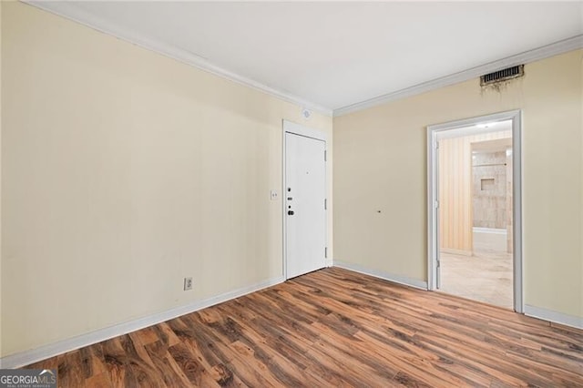 spare room featuring ornamental molding and hardwood / wood-style flooring