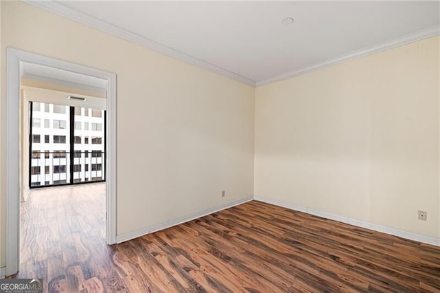 spare room featuring ornamental molding and dark wood-type flooring