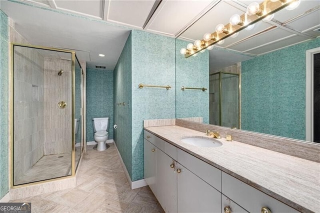 bathroom with an enclosed shower, vanity, and toilet