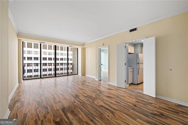 spare room featuring wood-type flooring and ornamental molding