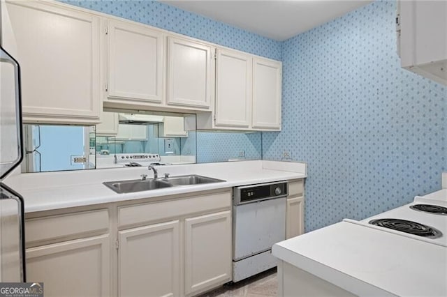 kitchen featuring white dishwasher, white cabinetry, and sink