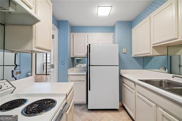 kitchen with white cabinetry, sink, and white appliances