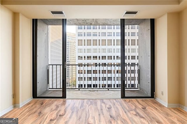 interior space featuring expansive windows and hardwood / wood-style flooring