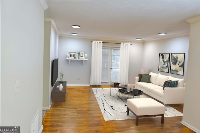 living room with light hardwood / wood-style flooring and crown molding