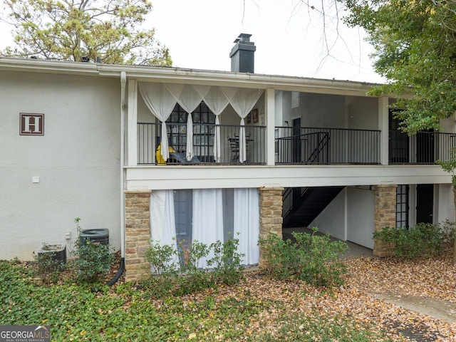 back of property featuring central AC unit and a balcony