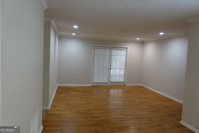 spare room featuring ornamental molding and hardwood / wood-style flooring