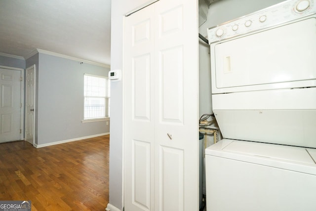 washroom with crown molding, hardwood / wood-style flooring, and stacked washer and dryer