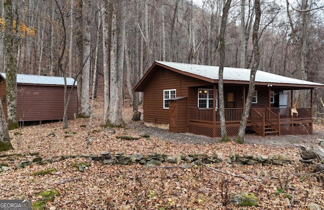 exterior space featuring a porch and an outdoor structure