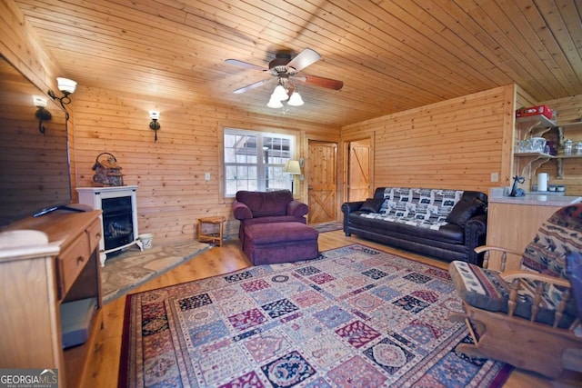 living room featuring ceiling fan, wood walls, hardwood / wood-style flooring, and wood ceiling