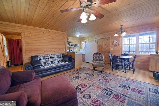 living room with ceiling fan, wood walls, light wood-type flooring, and wooden ceiling