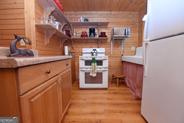 kitchen featuring white appliances, light hardwood / wood-style floors, wooden ceiling, and wood walls