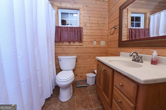 bathroom featuring tile flooring, wood walls, toilet, and vanity