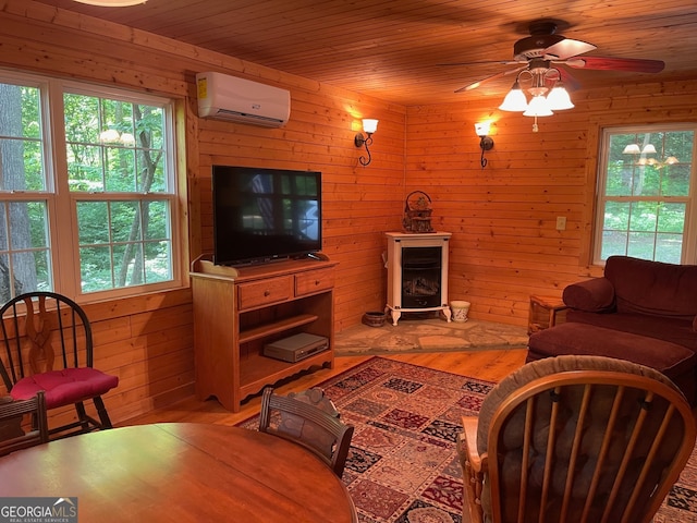 living room with wooden walls, ceiling fan, hardwood / wood-style floors, and a wall mounted AC