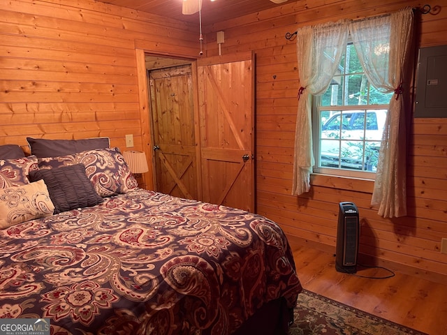 bedroom featuring wood-type flooring and wooden walls