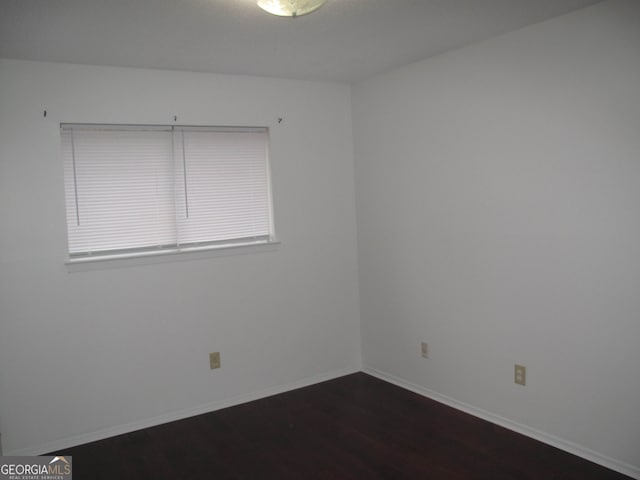 empty room with dark hardwood / wood-style flooring