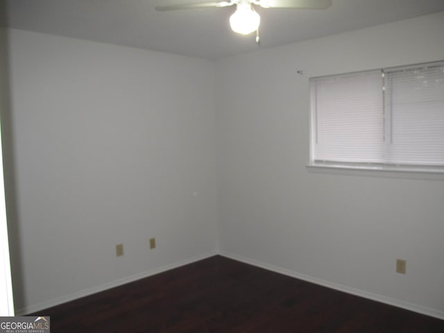 spare room featuring ceiling fan and dark hardwood / wood-style floors