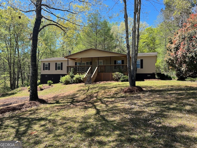 rear view of property featuring a deck and a yard