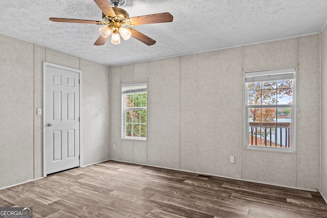 unfurnished room featuring ceiling fan, a textured ceiling, and wood-type flooring