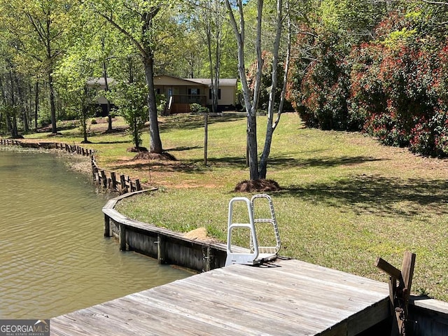 view of dock featuring a lawn and a water view