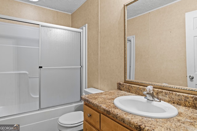 full bathroom with a textured ceiling, combined bath / shower with glass door, vanity, and toilet