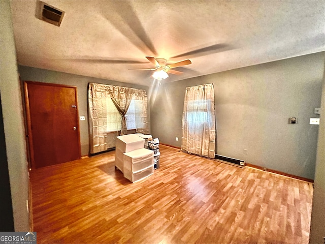 unfurnished room with ceiling fan, a textured ceiling, and wood-type flooring