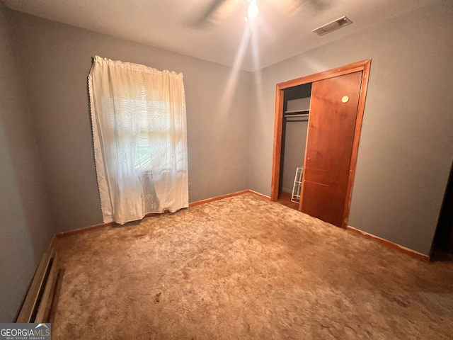 unfurnished bedroom with carpet, a closet, and ceiling fan