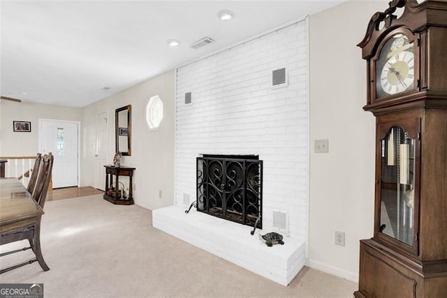 carpeted living room featuring a brick fireplace