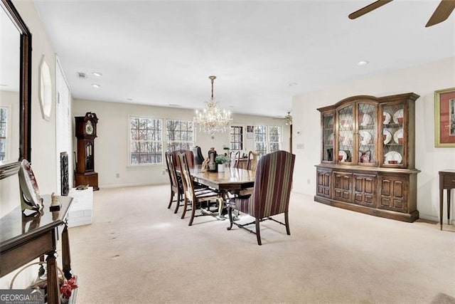 dining room featuring ceiling fan with notable chandelier and light carpet