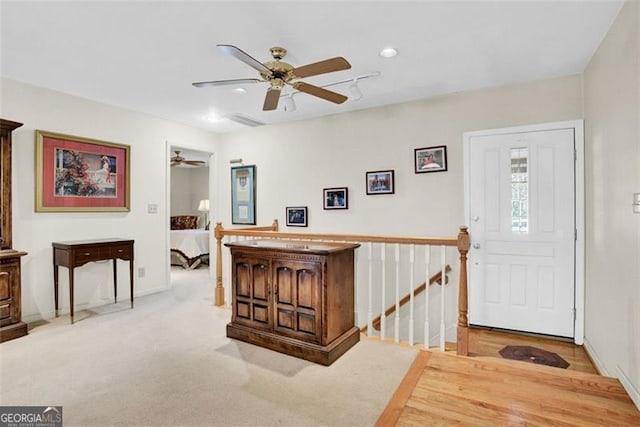 entryway with ceiling fan and light colored carpet