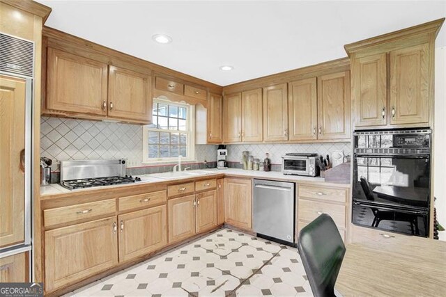 kitchen featuring appliances with stainless steel finishes, sink, and tasteful backsplash