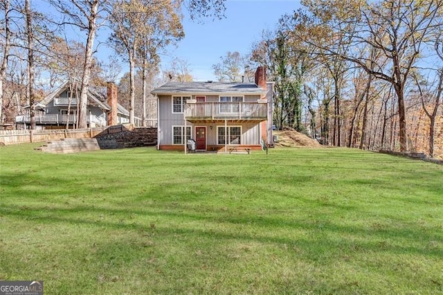 back of house featuring a deck and a lawn