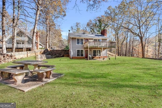 rear view of property with a wooden deck and a yard