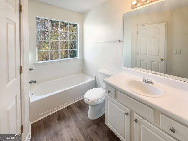 bathroom with a bathtub, toilet, wood-type flooring, and vanity