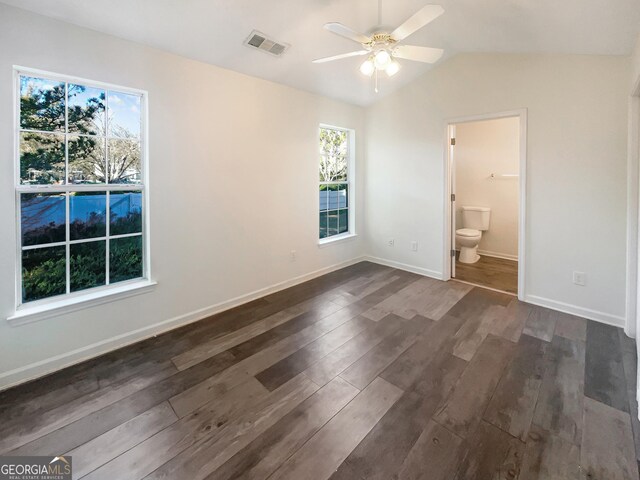 unfurnished bedroom with ensuite bath, vaulted ceiling, ceiling fan, and dark hardwood / wood-style floors