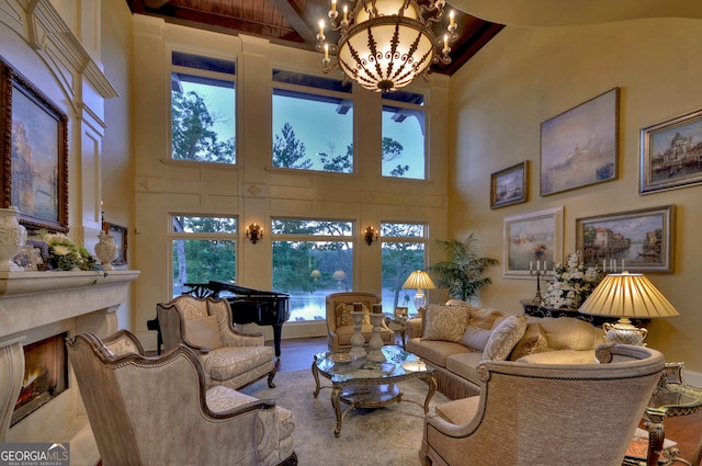 living room with plenty of natural light, a high end fireplace, high vaulted ceiling, and a notable chandelier