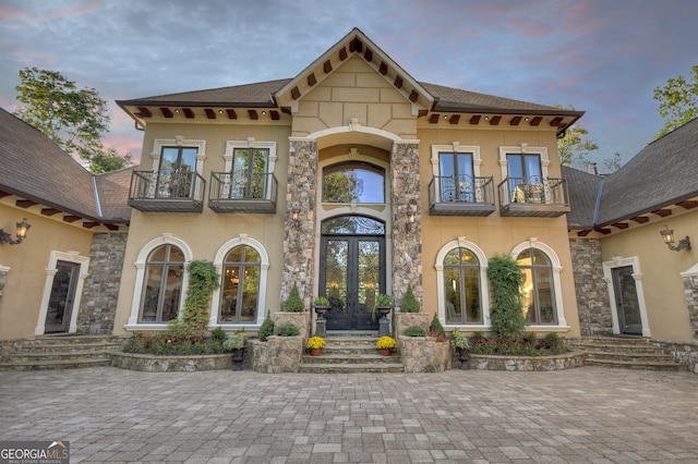 mediterranean / spanish home featuring a balcony and french doors