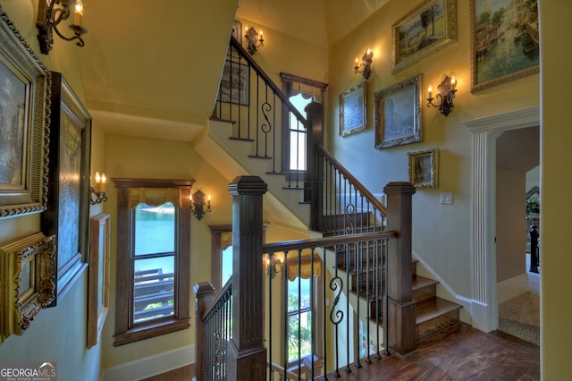 stairs featuring wood-type flooring and a towering ceiling